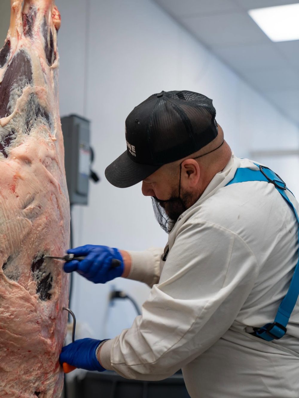 Skyline Meats butcher hand-trimming beef in the shop
